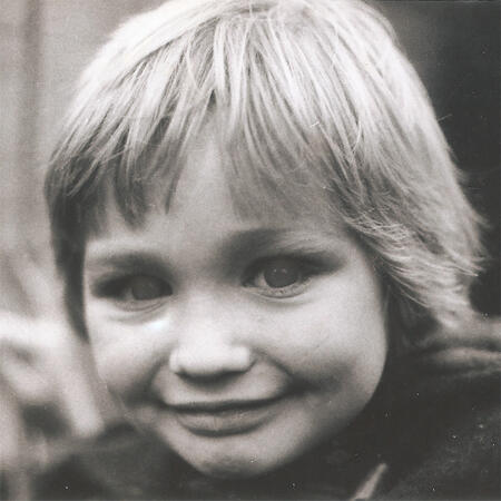 A black and white childhood photo of Matt Cruse, showing a young child with light hair smiling at the camera.